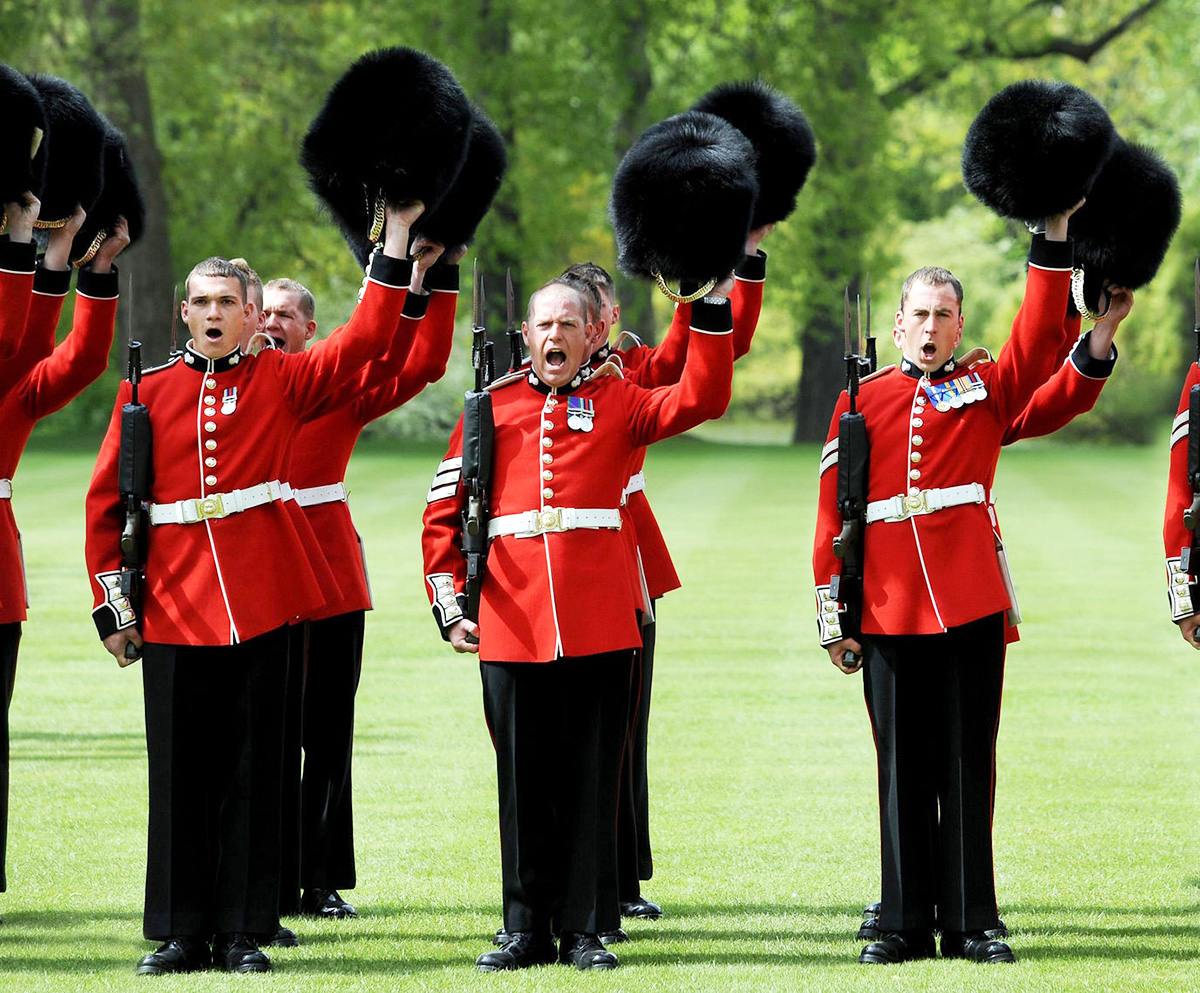 Гренадерские гвардейцы приветствуют королеву Елизавету II после того, как она подарила полку новые цвета в саду Букингемского дворца 11 мая 2010 года в Лондоне, Англия